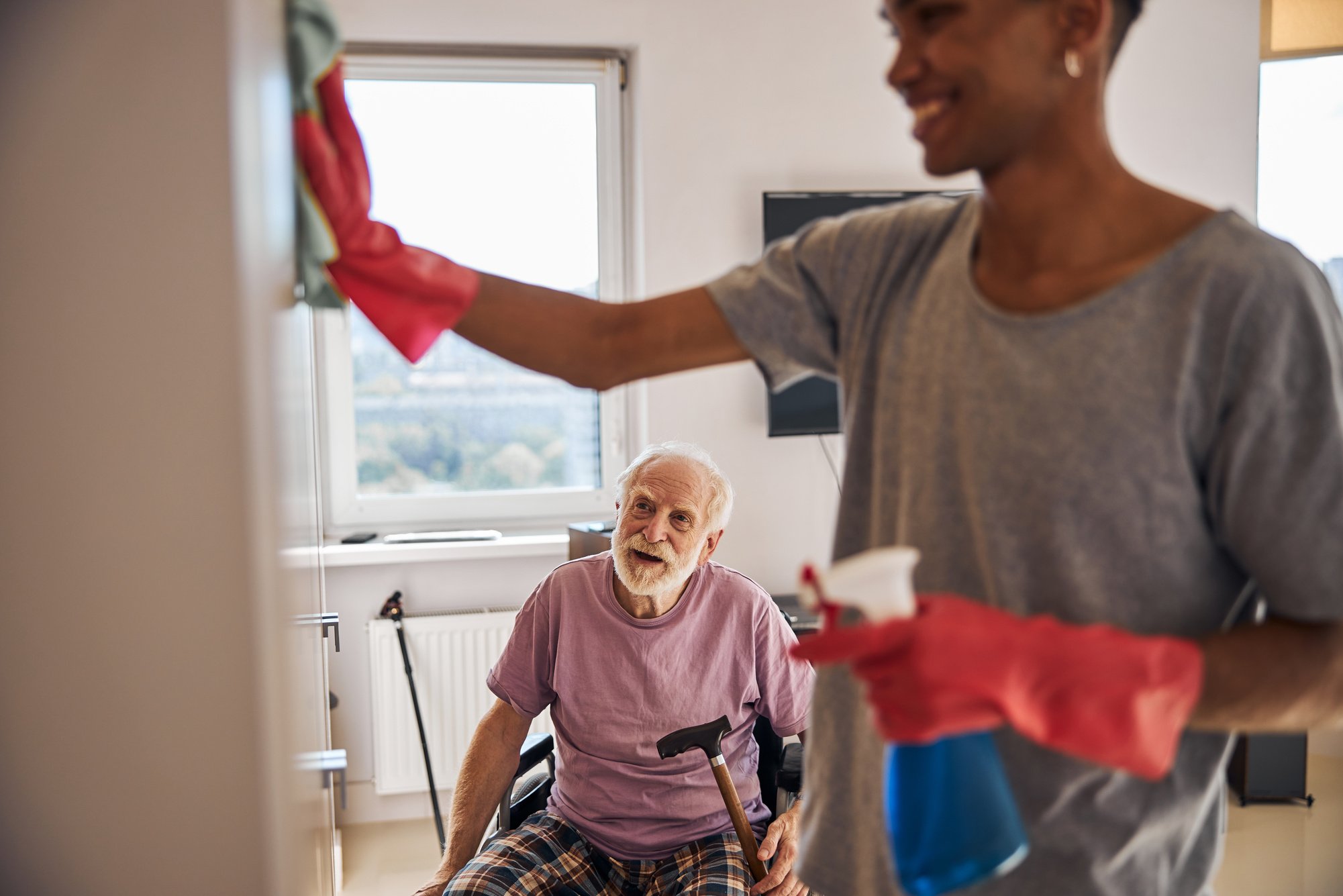 Volunteer helping a disabled person clean his home